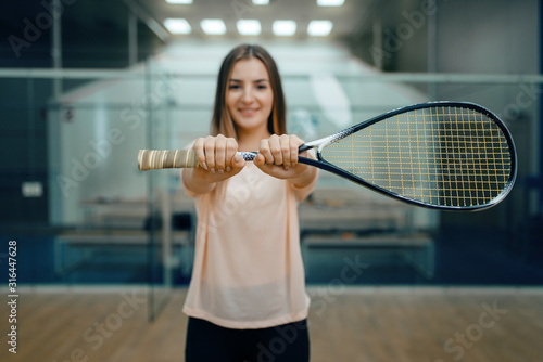 Female player shows squash racket on court © Nomad_Soul