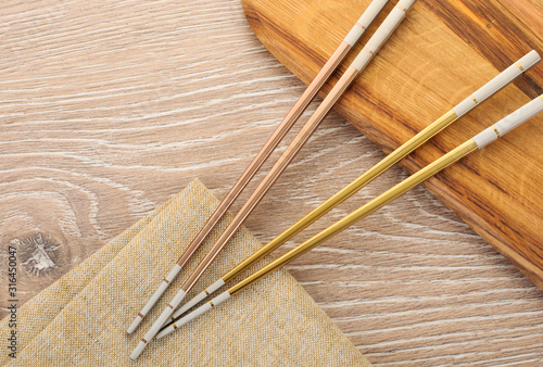 asian golden chopsticks on wooden brown background