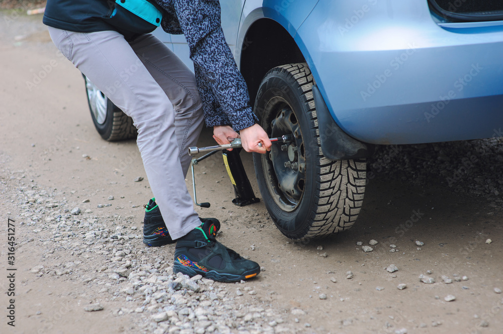 Man is changing tire with wheel on the car Man is changing tire with wheel on the car