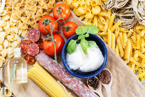 composition of raw pasta different shapes and cooking products, frame of raw Ingredients . room for text  photo