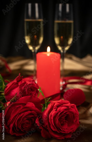 Valentine's day card, two glasses of champagne on a gold background red roses and a red heart, a lighted candle
