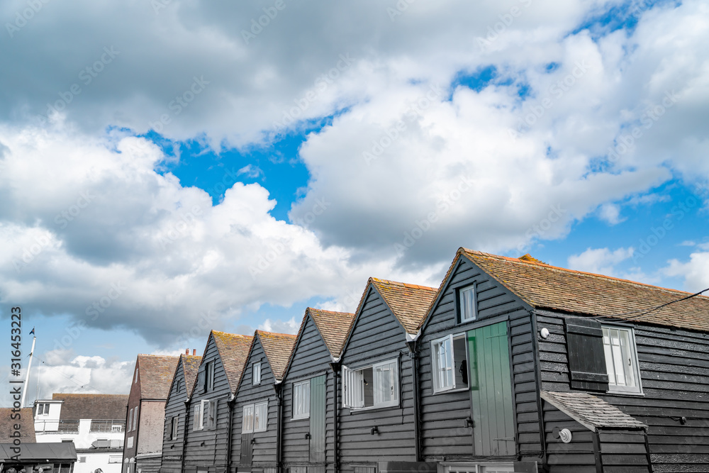 Black row of terrace style holiday homes from converted boatsheds.