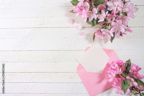 Fototapeta Naklejka Na Ścianę i Meble -  Card with pink envelope and pink flowers on wooden board.