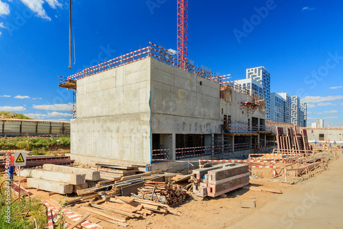 concrete pump building under construction. Concrete pump on high rise building under construction site with crane. Cement mixer truck with pump is preparing to put concrete on foundation.  photo