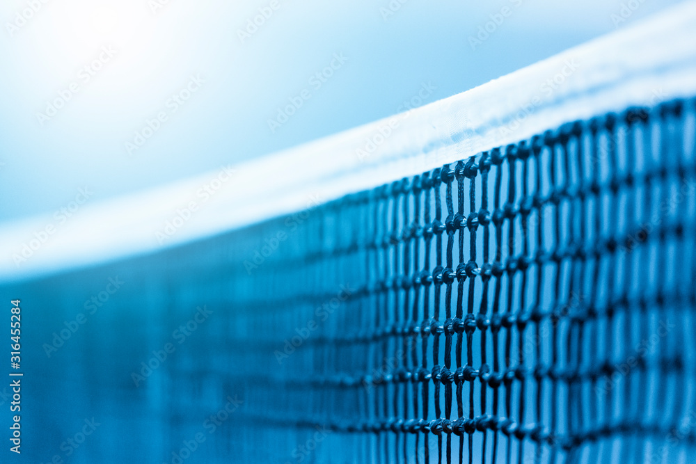 Tennis net and blue court. Individual sport. Blue filter - obrazy, fototapety, plakaty 