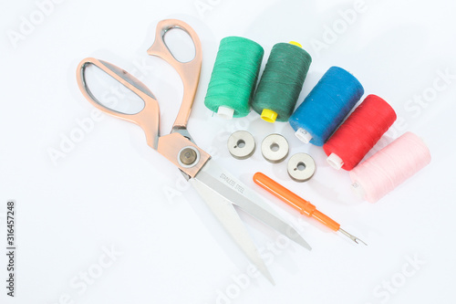 scissors and spools of thread on white background