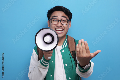 Young Asian Male Student With Megaphone Advertisement Concept, Smiling Expression