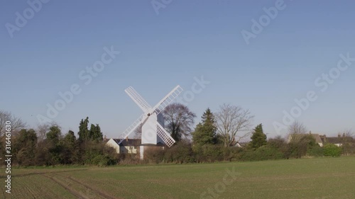 White windmill in the countryside aerial 4k  photo