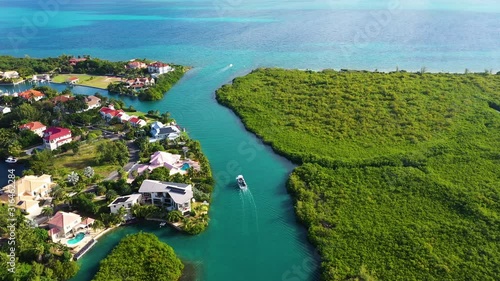 aerial drone footage of the island of grand cayman in the cayman islands in the tropical clear blue waters of the caribbean sea showing west bay, north sound, seven mile beach and yachts