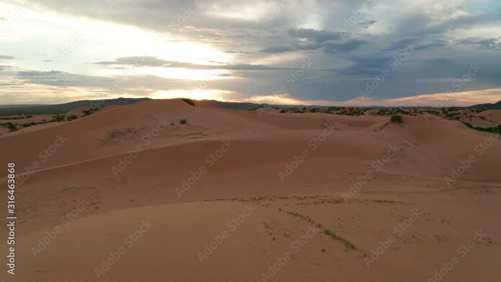 Sunset over the sand dunes in the desert. Aerial view Sunset over the sand dunes in the desert. Aerial view