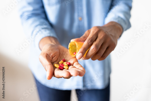 Hand Holding Pill Bottle and pills