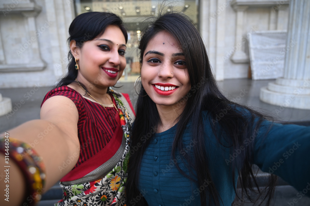 Happy Indian woman and adult girl taking selfie and making funny faces  while shopping Stock Photo | Adobe Stock