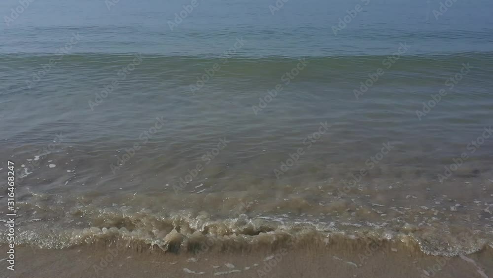 Slow motion sea water hitting sandy beach Slow motion sea water hitting sandy beach