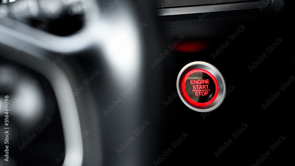 Obraz premium Close up modern car engine start stop button on black leather car console and copy space