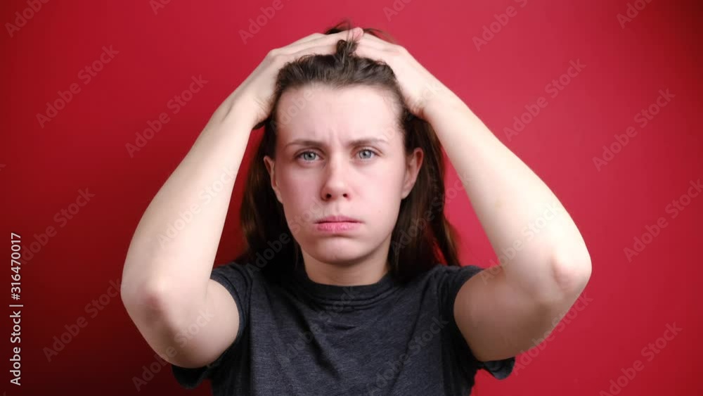 Terrible furious woman yells angrily, tearing hair out feeling tension and stress while facing problems, can't stand pressure, clenching teeth and keeping eyes popped out, isolated on red background Terrible furious woman yells angrily, tearing hair out feeling tension and stress while facing problems, can't stand pressure, clenching teeth and keeping eyes popped out, isolated on red background