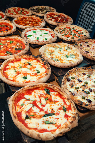 Lots of pizzas on wooden background. Pizza party