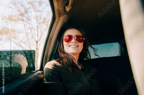 redhead girl sitting on back seat of a car and wind waving her hair photo