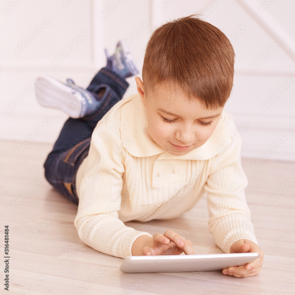 Cute boy. Computer tablet. Training. light interior Cute boy. Computer tablet. Training. light interior