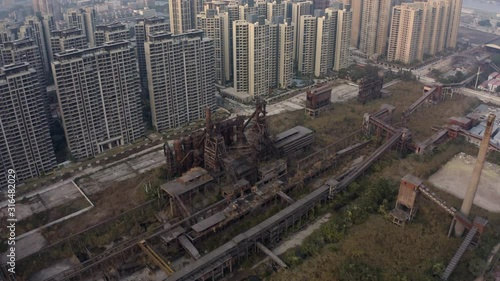 Aerial shot of an old steel mill refinery in between living apartment blocks in newly  developing territories, Guangzhou, Guangdong, China photo