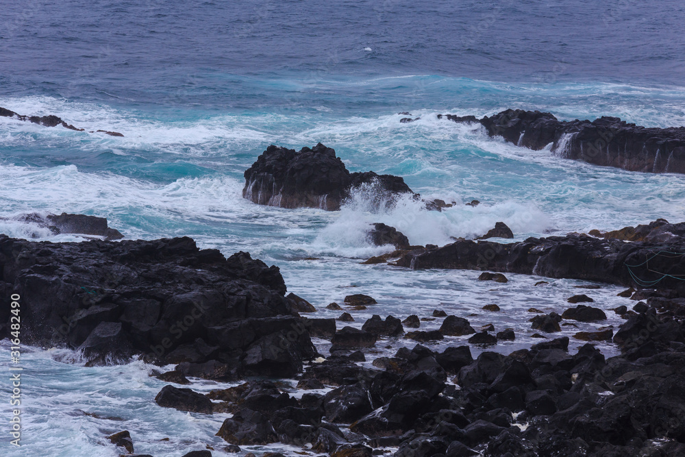 Beautiful Nature scene of sea wave hitting on the black stone shoreline at Jeju Island, South Korea. Beautiful Nature scene of sea wave hitting on the black stone shoreline at Jeju Island, South Korea.