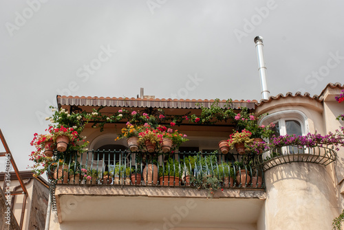 Kleiner Balkon mit vielen Blumen und Blumentöpfen