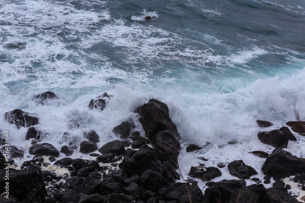 Beautiful Nature scene of sea wave hitting on the black stone shoreline at Jeju Island, South Korea. Beautiful Nature scene of sea wave hitting on the black stone shoreline at Jeju Island, South Korea.