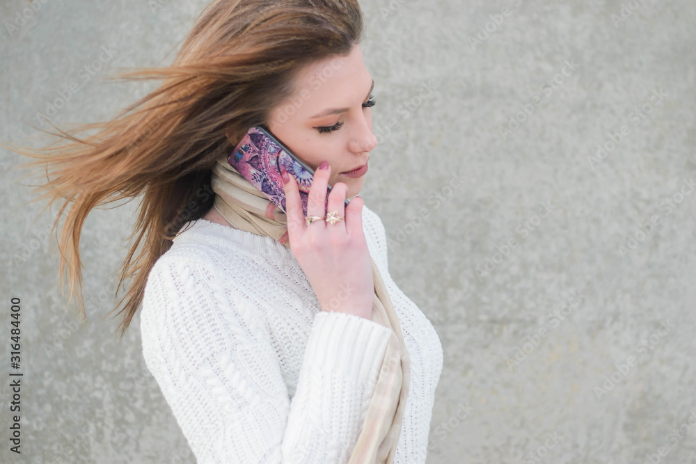 beautiful girl communicates on the phone about their business while strolling along the promenade of a big city beautiful girl communicates on the phone about their business while strolling along the promenade of a big city