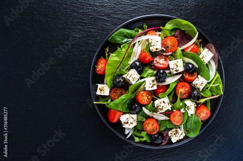 Fotografie, Obraz Fresh greek salad - feta cheese, tomato, lettuce, black olives and onion