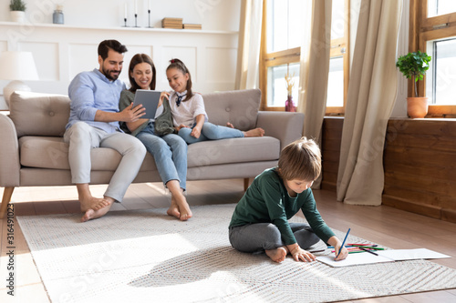 Young family with small kids relax in living room