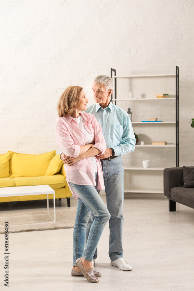 Happy senior couple dancing together in living room Happy senior couple dancing together in living room