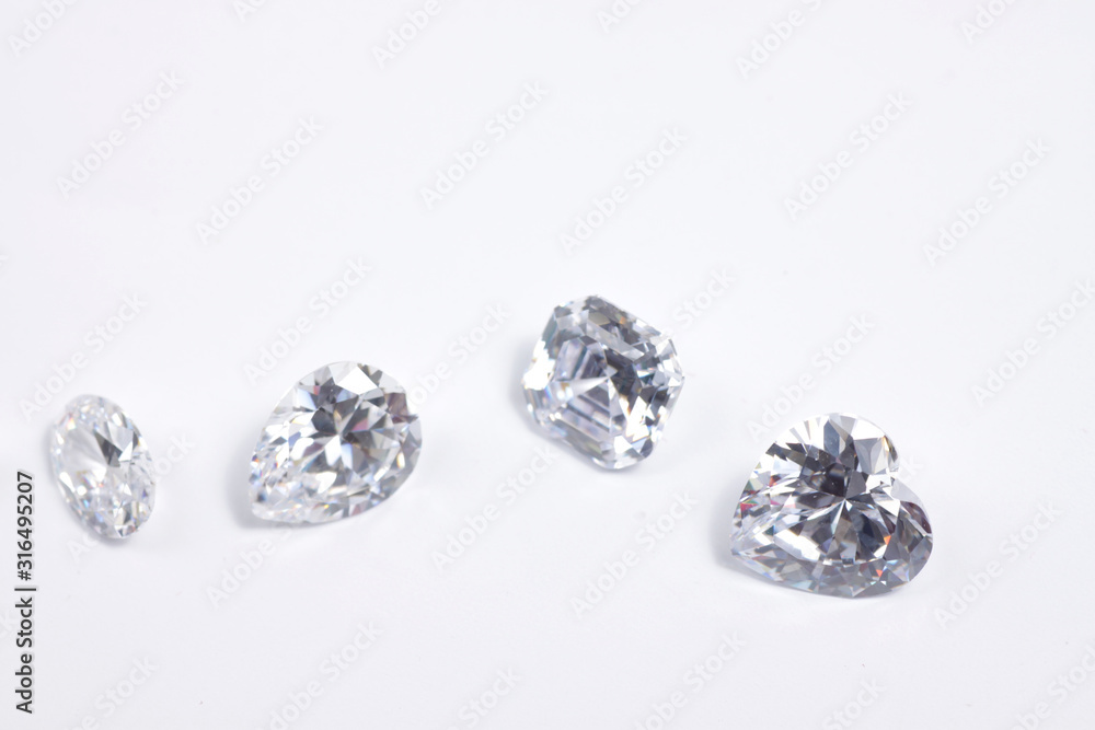 Macro shoots of a group of diamonds that has different shapes, heart, round, pear, asscher, oval, princess, isolated background