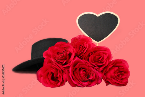 The red rose dress has a black hat  a sign written in a beautiful heart shape.