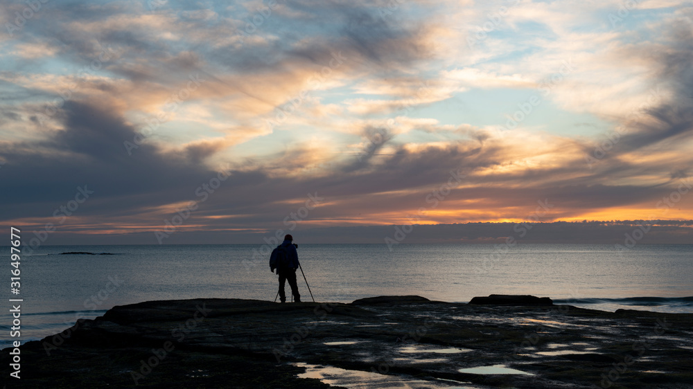 Photographer at Muriwai beach at sunset