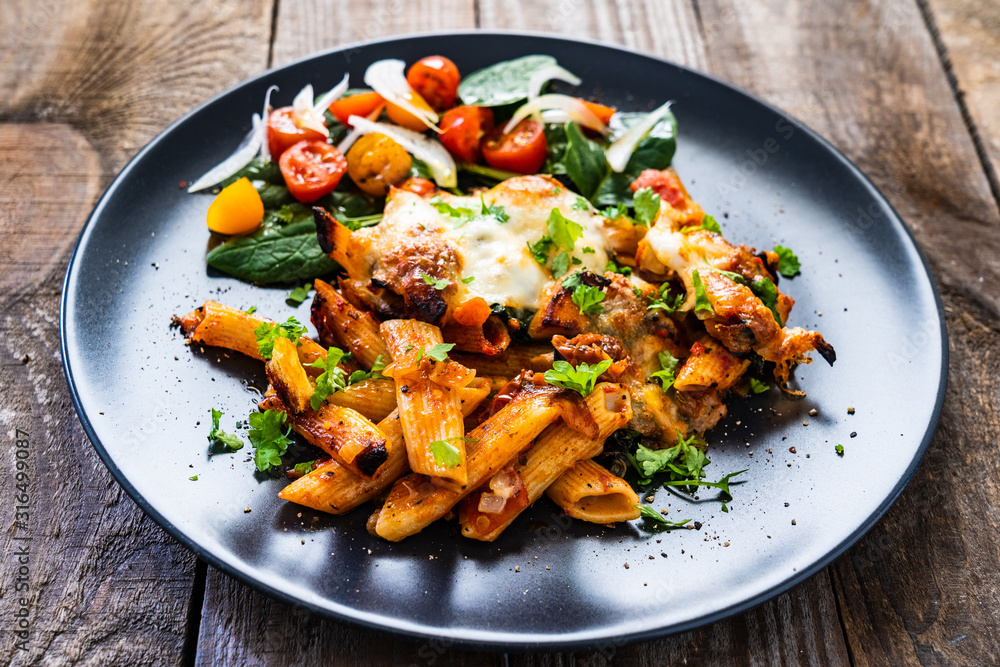Fototapeta premium Pasta casserole with barbecue chicken breast, cheese and vegetables