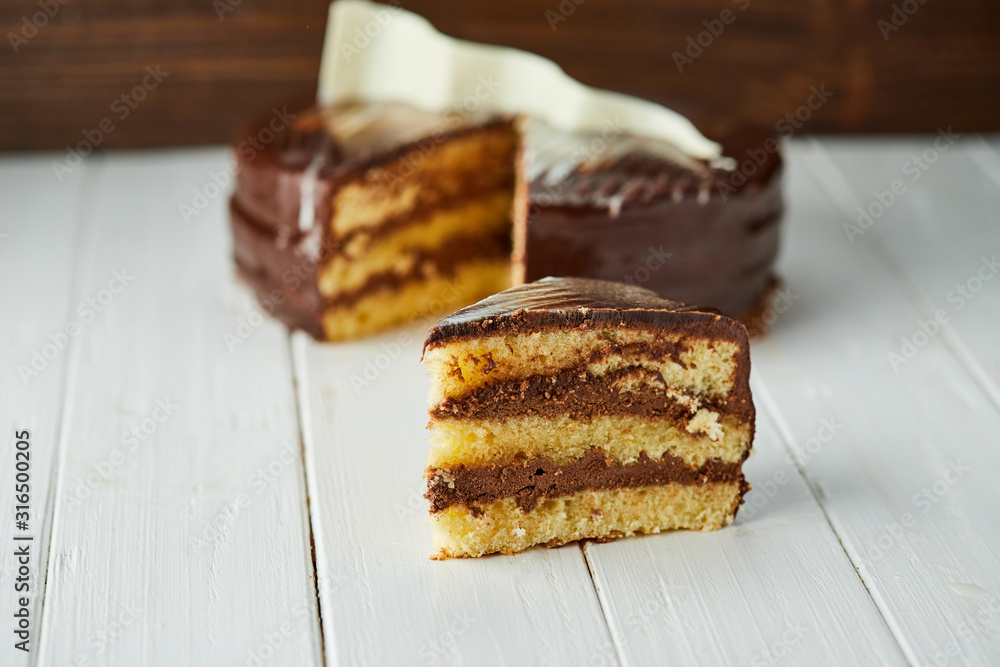 Dark chocolate vegan cake with candies and nuts on wooden background Dark chocolate vegan cake with candies and nuts on wooden background