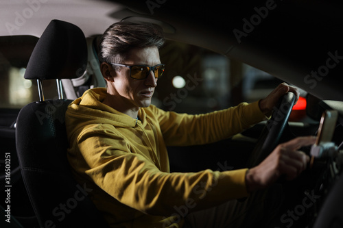 Driver man using smartphone in car phone holder at night © antgor