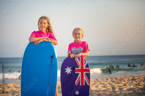 Konstfotografi Two Aussie girls on the beach with their body boards