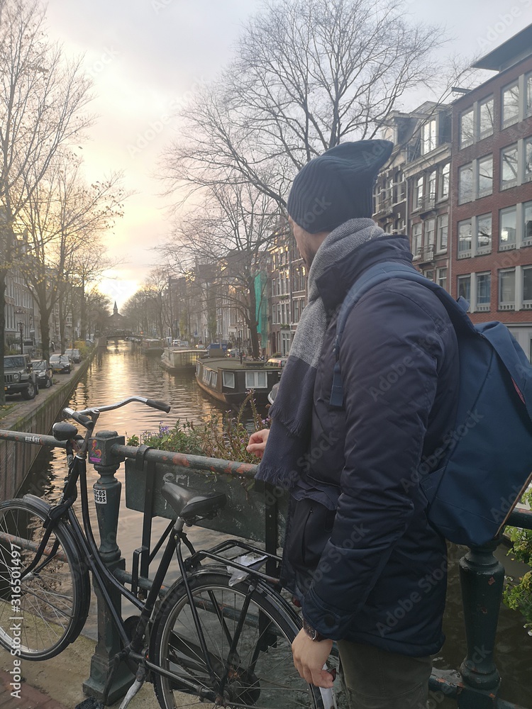 the famous canals of Amsterdam with the bikes and the flowers.many tourists stop by for a photo the famous canals of Amsterdam with the bikes and the flowers.many tourists stop by for a photo
