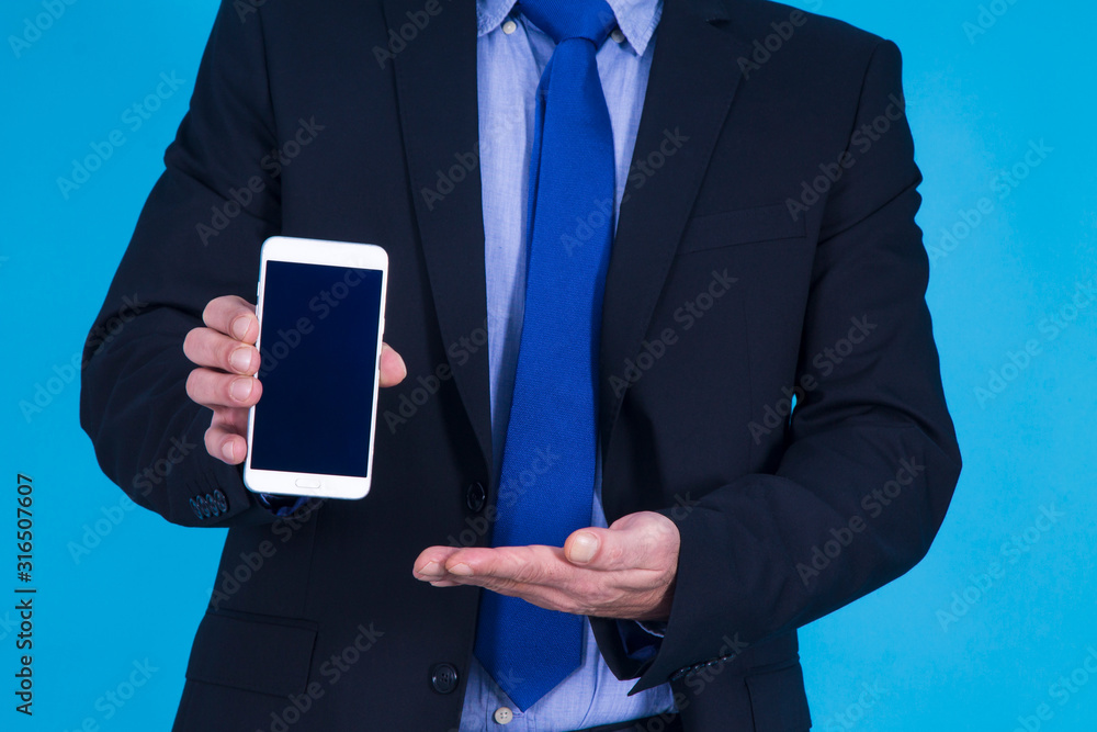 businessman showing mobile phone on blue background businessman showing mobile phone on blue background
