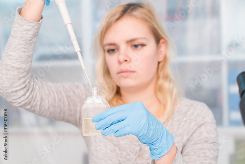Young attractive woman work with PCR dispenser in the laboratory of genetics