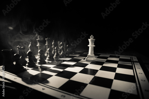 Chess figures on a dark background with smoke and fog. Selective focus