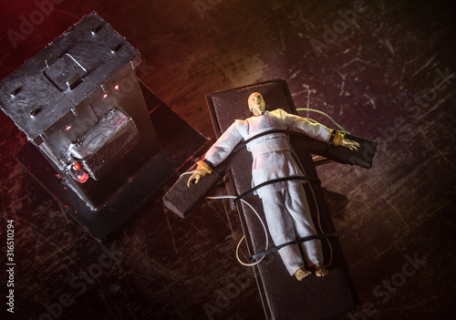 Prisoner handcuffed to death by lethal injection, vial with sodium thiopental and syringe on top of a table, conceptual image photo