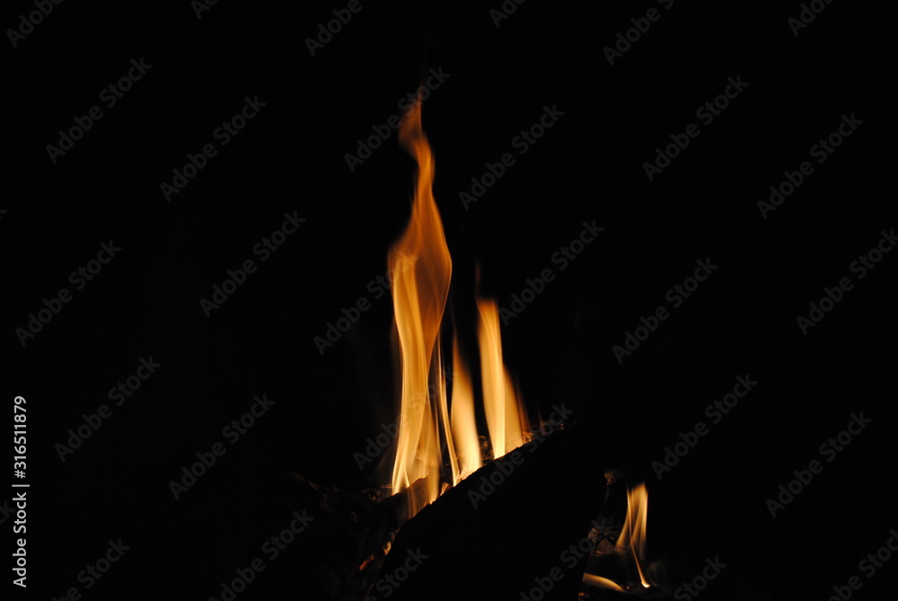 Fototapeta premium Log on fire in a black background.