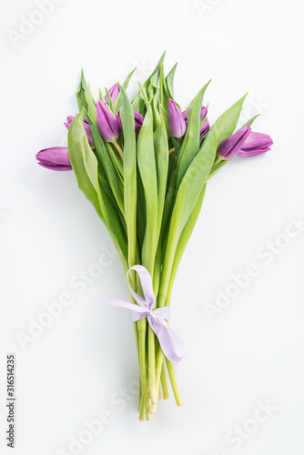 Bouquet of purple tulips on white top view