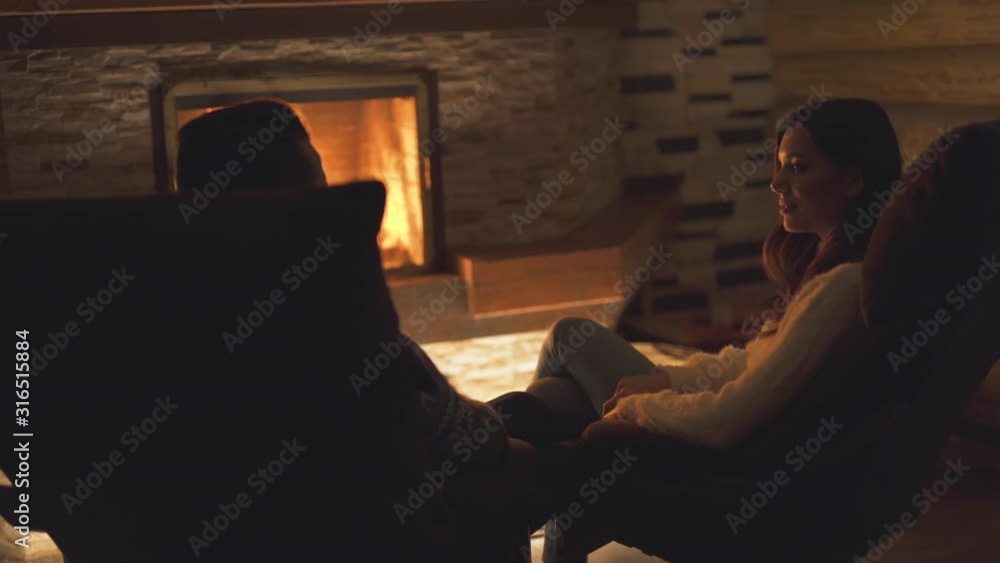 The man and woman have rest near the fireplace The man and woman have rest near the fireplace