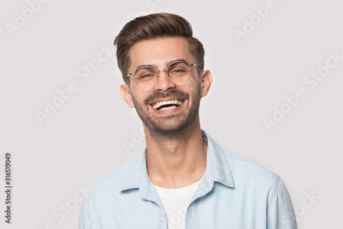 Head shot portrait young laughing happy man in eyeglasses.