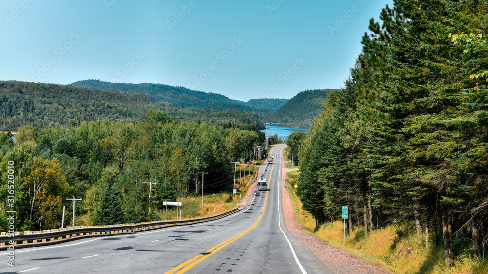 Road between forests and lakes of the Canadian state of Quebec.