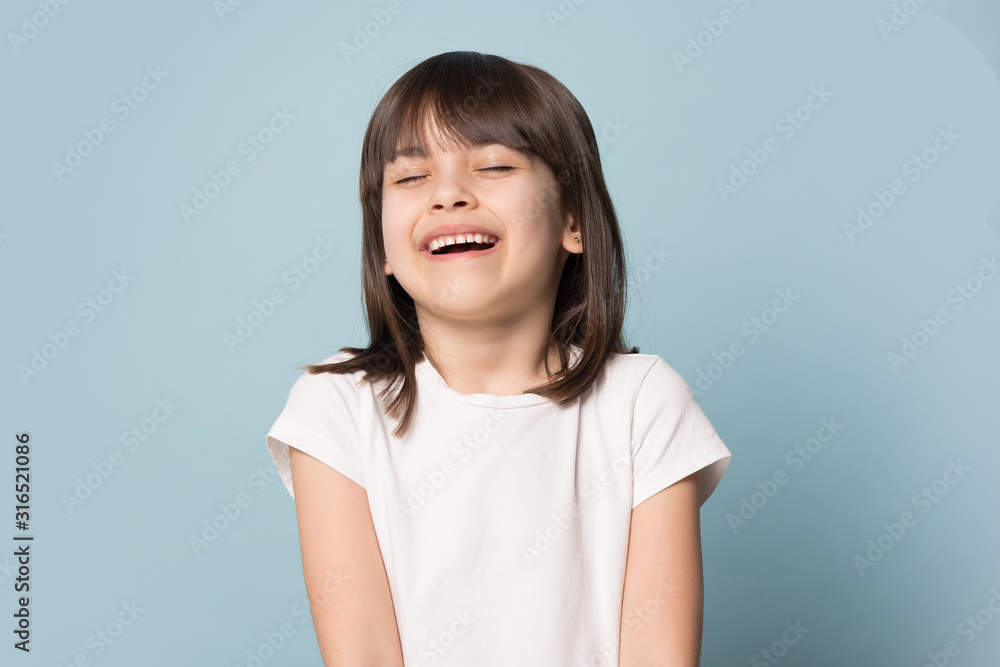 Happy preschool cutie laughing, joking, posing on blue background. - obrazy, fototapety, plakaty 