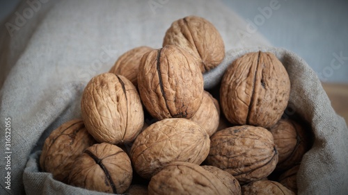 unpeeled walnuts in a gray canvas bag