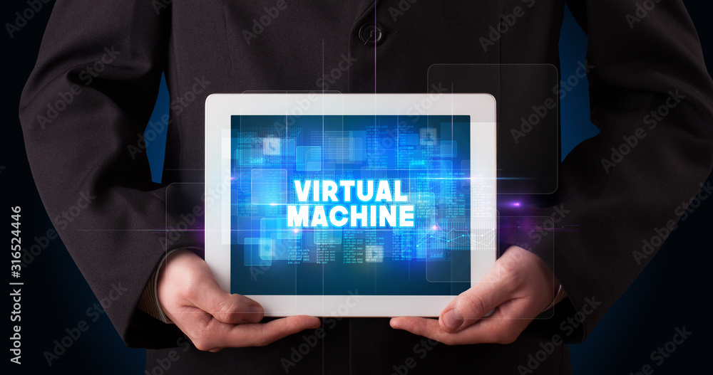 Young business person working on tablet and shows the inscription: VIRTUAL MACHINE Young business person working on tablet and shows the inscription: VIRTUAL MACHINE